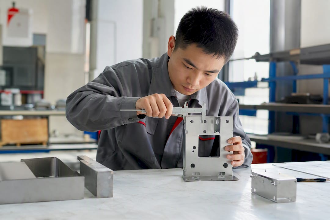 Engineer measuring sheet metal part in factory