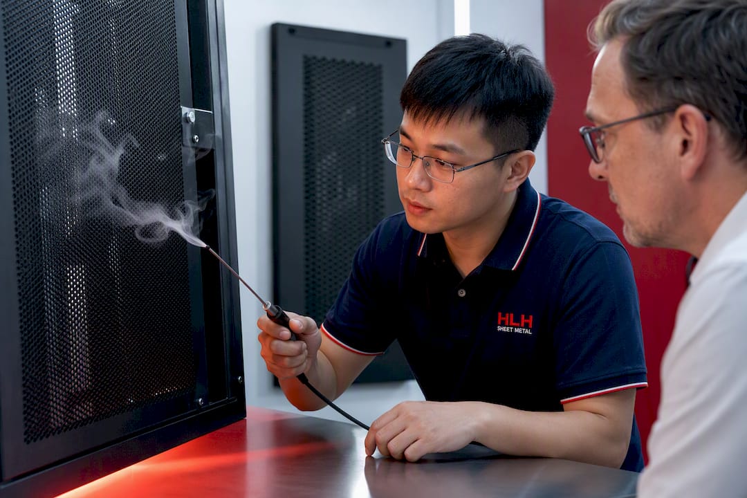 Engineer testing airflow across perforated cabinet panel